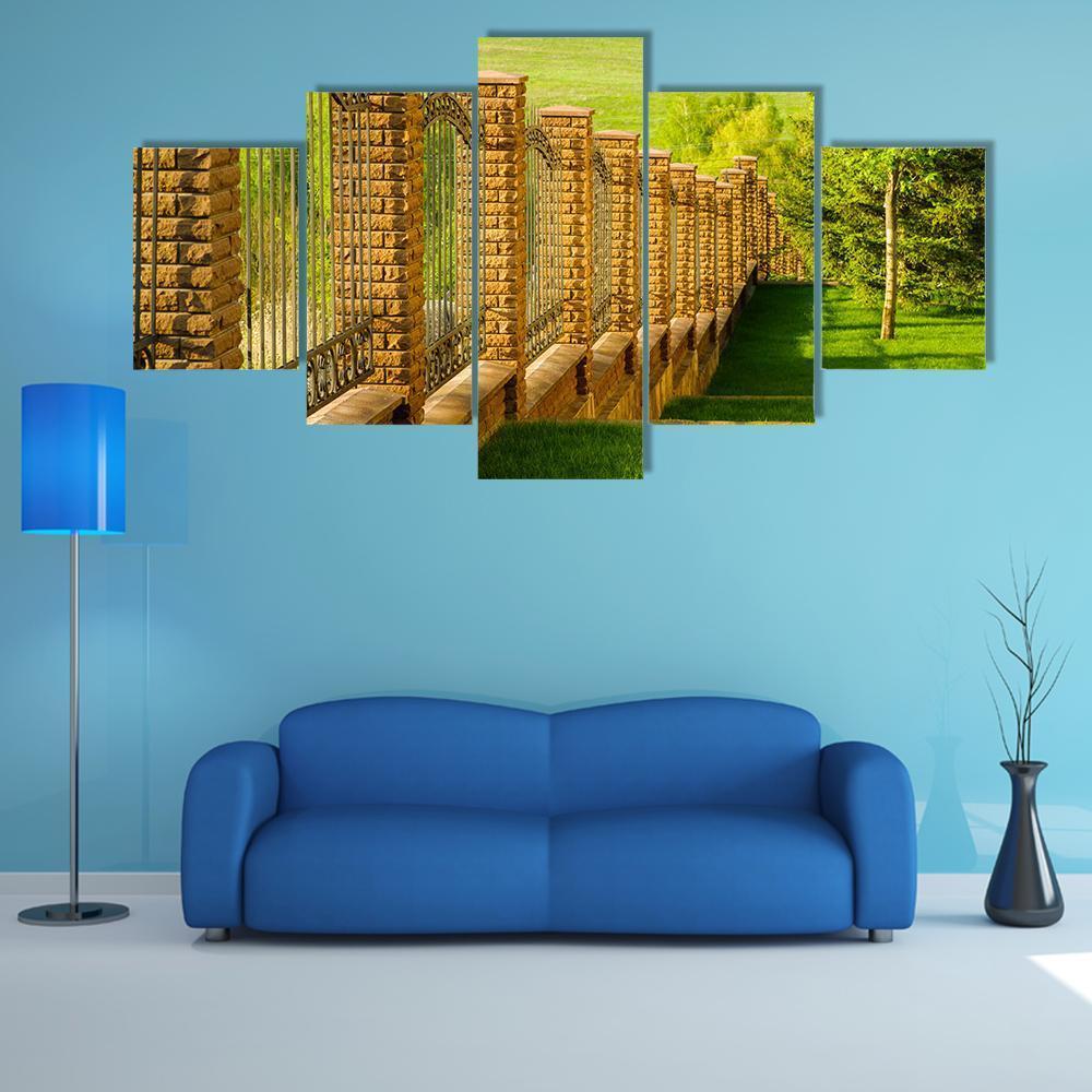 Forged Fence With Stone Pillars On Green Slope – Nature Canvas Wall Art